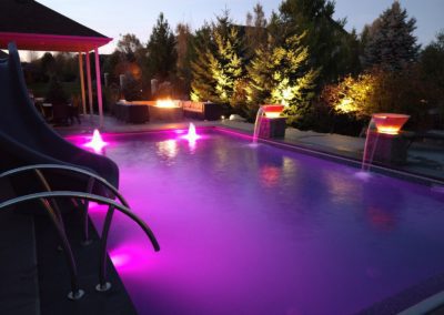 swimming pool built by creative structures at dusk with purple led lights